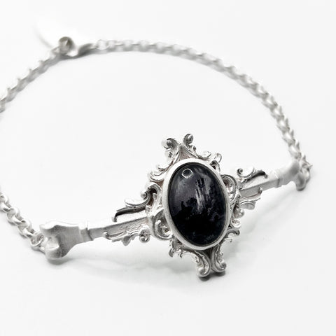 silver bracelet with a black Moonstone on it.