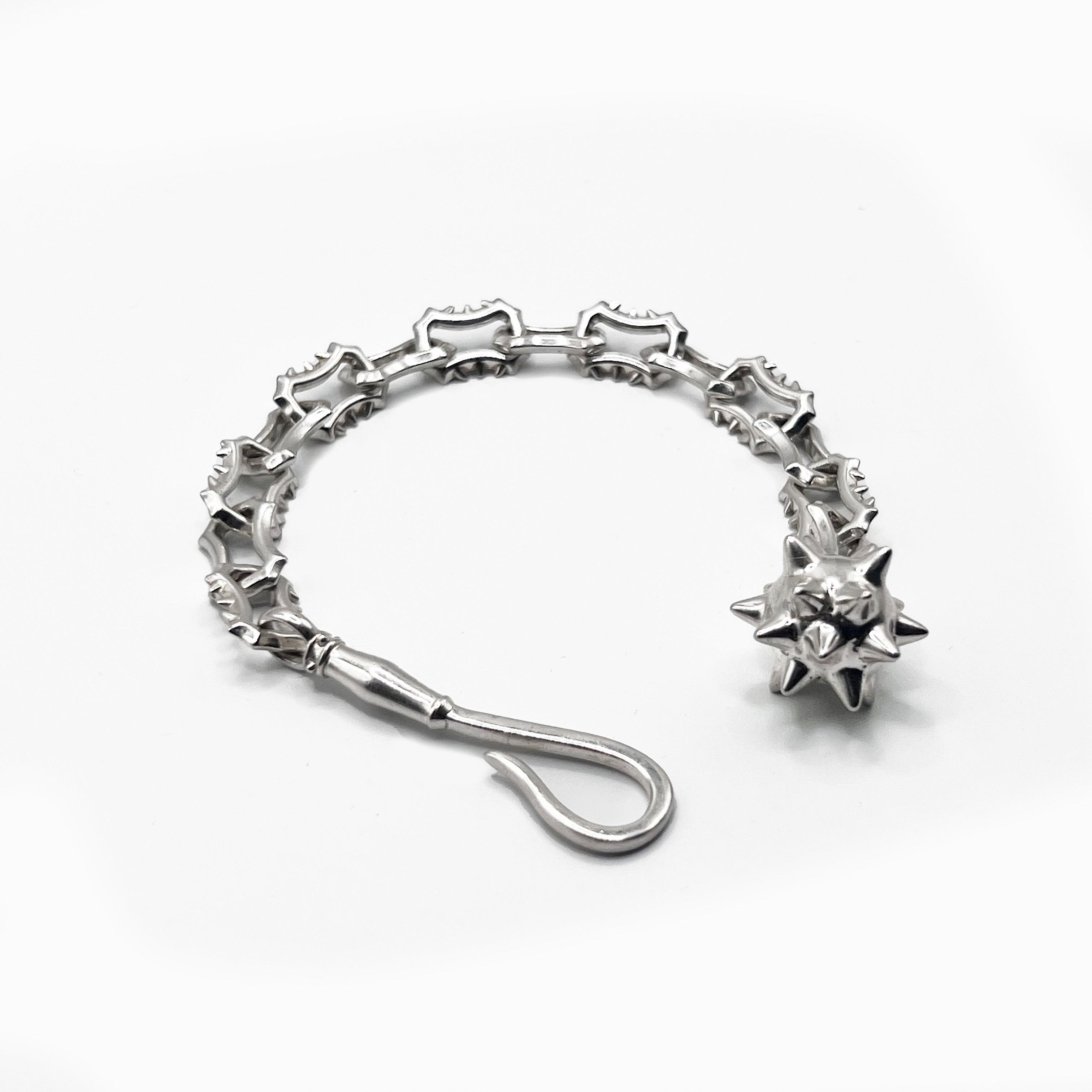 A silver chain bracelet with a star on it.