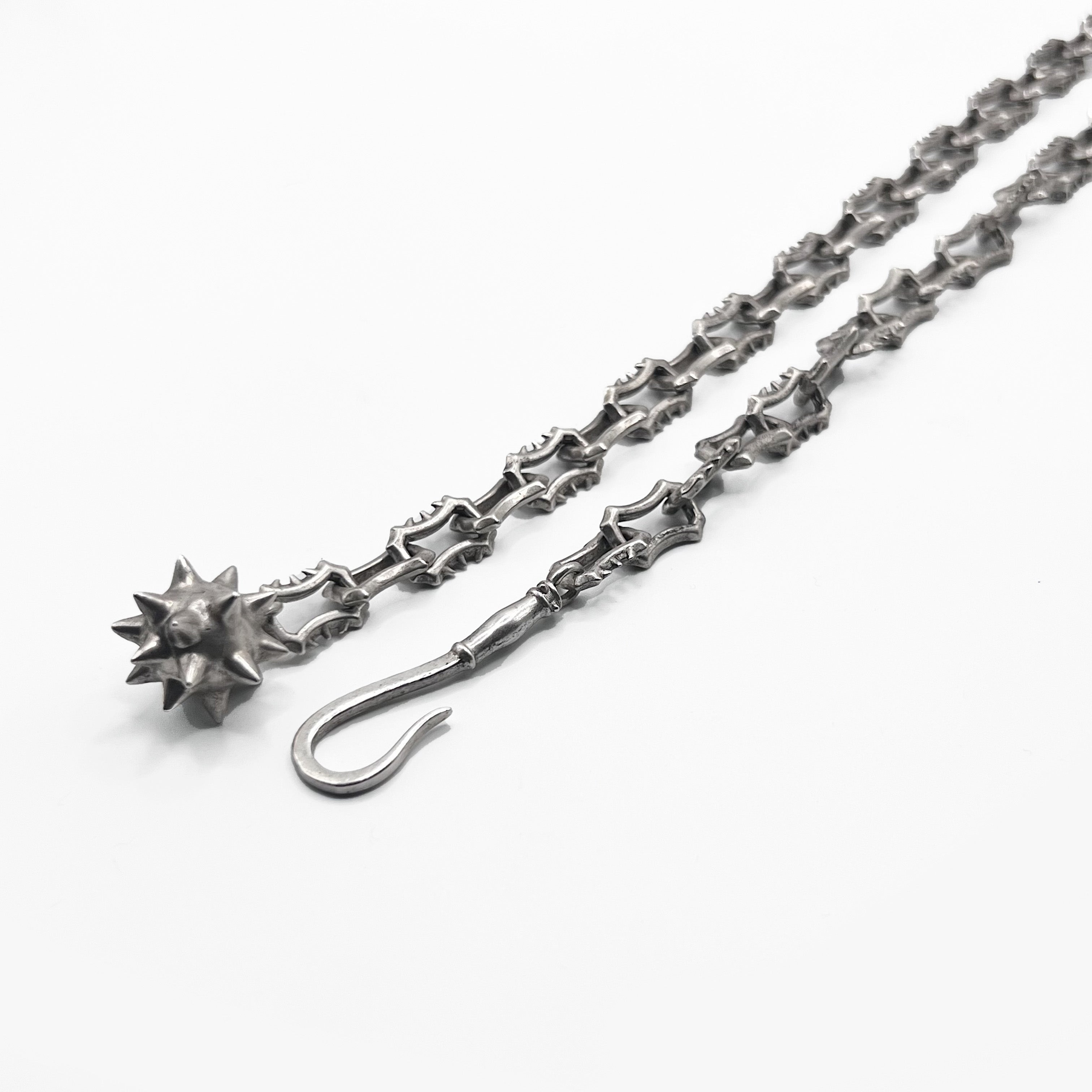 A silver chain bracelet with a star on it.