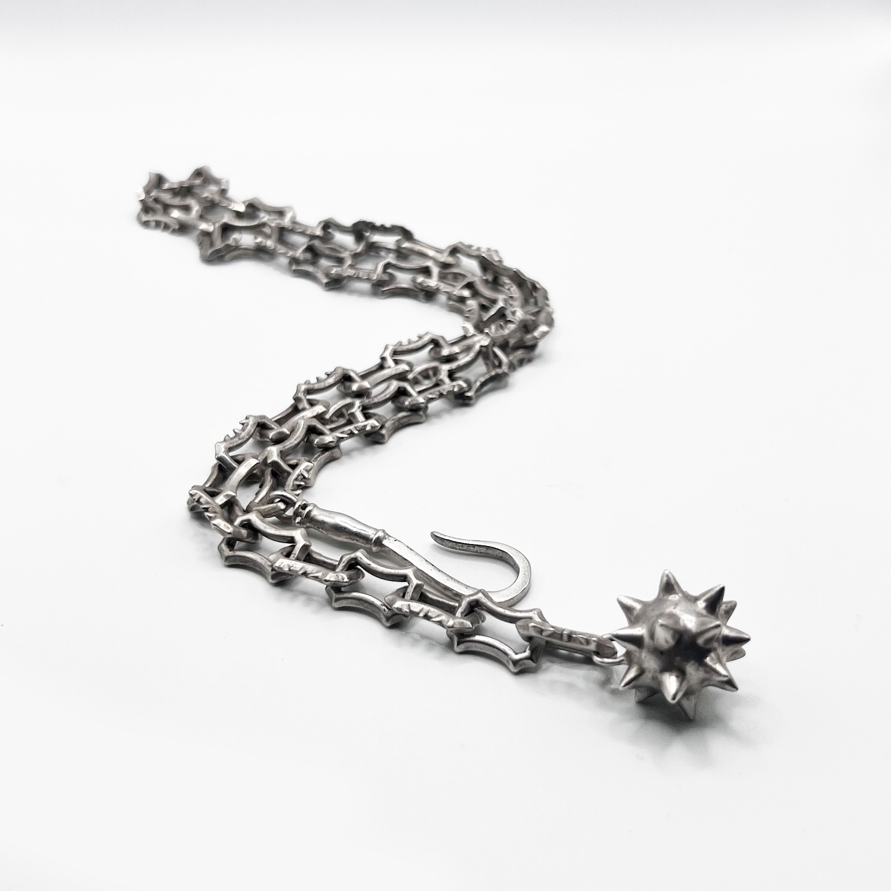 A silver chain bracelet with a star on it.