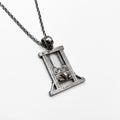 A guillotine pendant with a skull and chain on it.