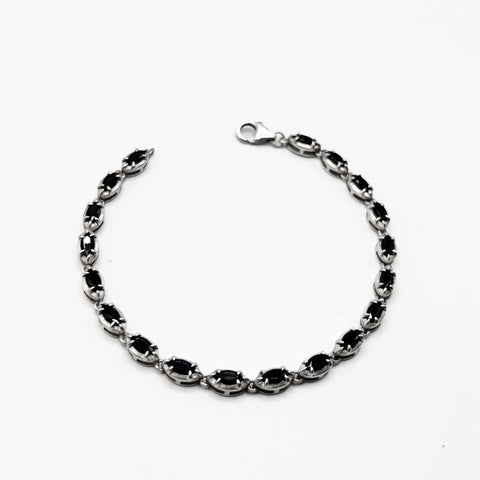 Silver  bracelet with black stones on it.