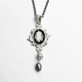 A necklace with a black and white image of a ghost.