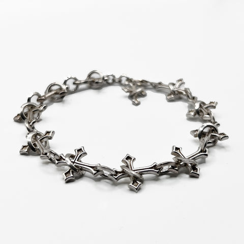 Sanctuary Chain  bracelet with a cross on it.